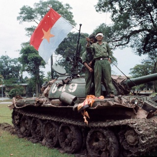 Ein Soldat der Nordvietnamesen schwenkt auf einem Panzer in Saigon am 30. April 1975 eine nordvietnamesische Flagge.