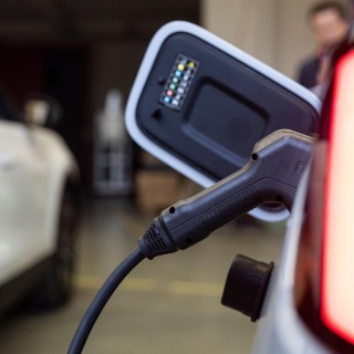 In einer Halle werden zwei Elektroautos mit Strom betankt.