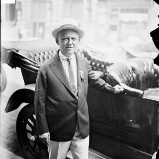 Carl Laemmle 1916 steht an einem Fahrzeug