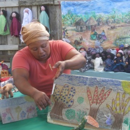 Eine Frau baut ein Marionettentheater auf einer Straße in Kapstadt auf.
