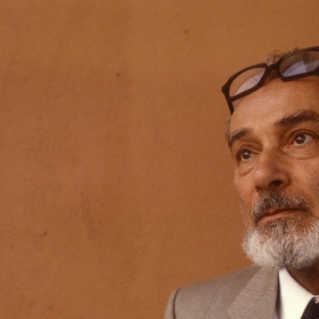 Porträt von Primo Levi vor einer occa farbigen Wand ca. 1980.