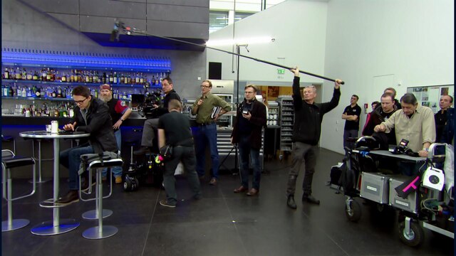 Ein Fernseh-Team mit Kamera und Tonangel dreht in einer Bar
