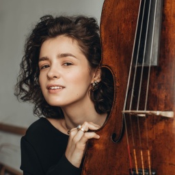 Eine junge Frau steht neben einem Musikinstrument