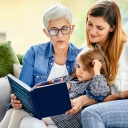 Oma, Mutter und Tochter lesen gemeinsam ein Buch