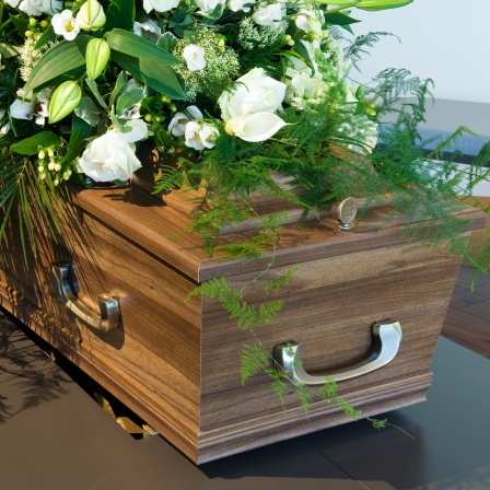 Sarg mit Blumen: Warum bestatten wir unsere Toten in Särgen?