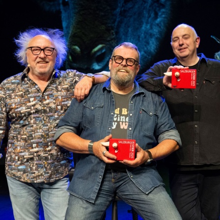 Die Kabarettisten Urban Priol, Jochen Malsmheimer und Frank Goosen posieren lachend auf der Bühne