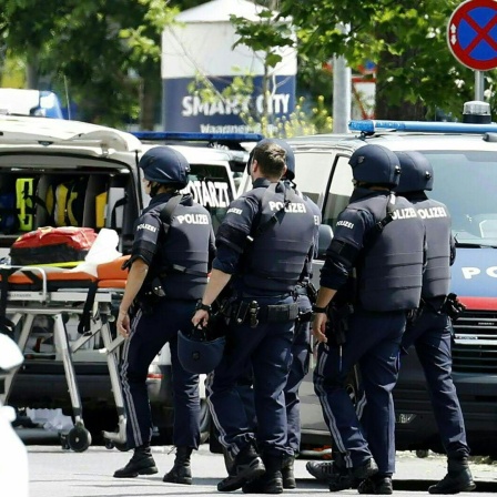Einsatzkräfte eines Polizei-Großeinsatzes stehen in einer Grazer Schule in der Dreierschützengasse in der Nähe des Tatorts.