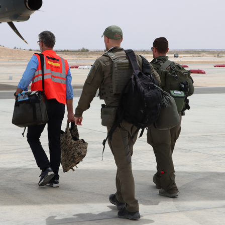 Drei Männer laufen auf der Luftwaffenbasis in Al-Asrak zu einem Transportflugzeug der Bundeswehr.