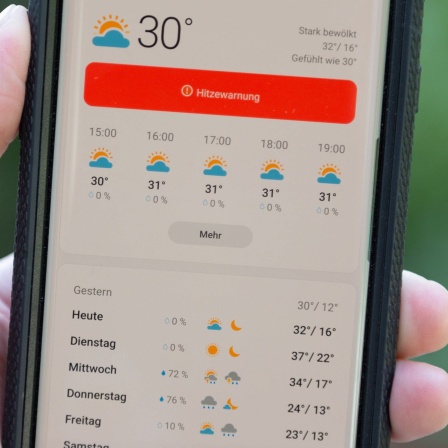 &#034;Hitzewarnung&#034; steht auf dem Display eines Smartphones in einer Wetter-App.