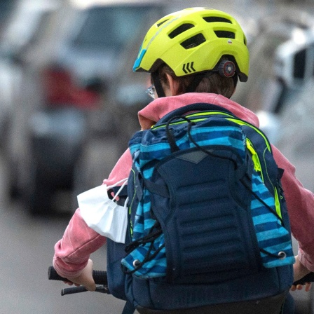Junge mit dem Fahrrad auf dem Weg zur Schule