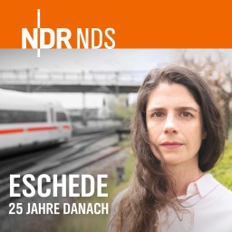 Eine Frau steht vor Bahngleisen in Eschede.