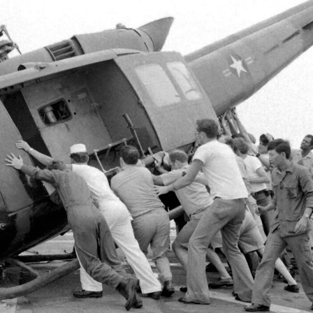 Menschen versuchen, in einen Hubschrauber zu gelangen: Dem Fall der Stadt Saigon ging die Evakuierung fast des gesamten amerikanischen Zivil- und Militärpersonals voraus, zusammen mit Zehntausenden südvietnamesischer Zivilisten, die mit dem südlichen Regime in Verbindung standen. Die Evakuierung gipfelte in der &#034;Operation Frequent Wind&#034;, der größten Hubschrauberevakuierung der Geschichte.