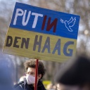 Ein Demonstrant hält auf einer Demo gegen den russischen Angriffskrieg ein Plakat in der Hand.