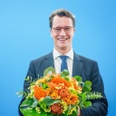 Hendrik Wüst (CDU), Ministerpräsident von Nordrhein-Westfalen, steht mit Blumen neben Friedrich Merz.