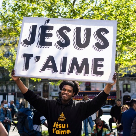 Ein evangelikaler Missionar auf dem Platz der Republik hält ein Plakat mit der Aufschrift "Jesus liebt Dich" in die Höhe