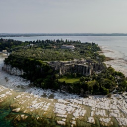 Eine Luftaufnahme vom 28. April 2023 zeigt die Halbinsel Sirmione am Gardasee in Norditalien, während der Wasserspiegel des Sees aufgrund einer schweren Dürre gesunken ist. 