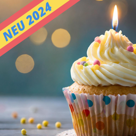 A beautifully decorated cupcake with white frosting and a lit candle, sitting on a wooden surface with a bokeh background, capturing a festive celebration moment