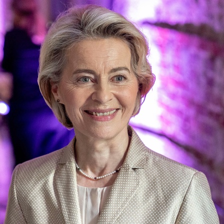 EU-Kommissionspräsidentin Ursula von der Leyen lächelt bei einer Veranstaltung in die Kamera.