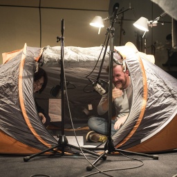 Sprecher Nico Holonics, in einem Zelt im Tonstudio sitzend
