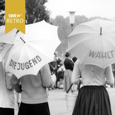 Frauen unter Sonnenschirmen mit Aufschrift Die Jugend wählt, eine Aktion der SPD in Koblenz 1957