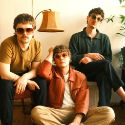 Drei Männer mit Sonnenbrillen in einem Wohnzimmer