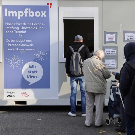 Menschen stehen Schlange vor der Impfbox in Wien - auch in Deutschland wird eine Impfpflicht diskutiert