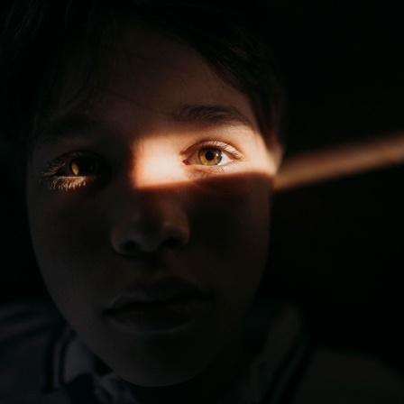 Lichtstrahl trifft Gesicht eines Kindes