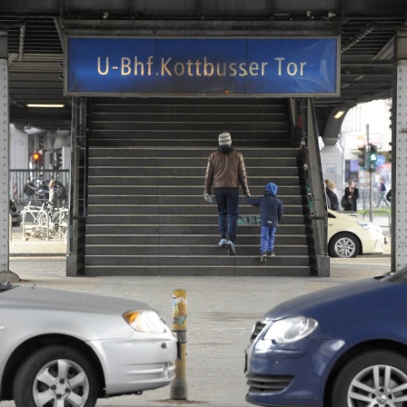 Ein Mann und ein Junge gehen am U-Bahnhof Kottbusser Tor die Treppe zur Hochbahn U1 hinauf (Bild: IMAGO / Klaus Martin Höfer)