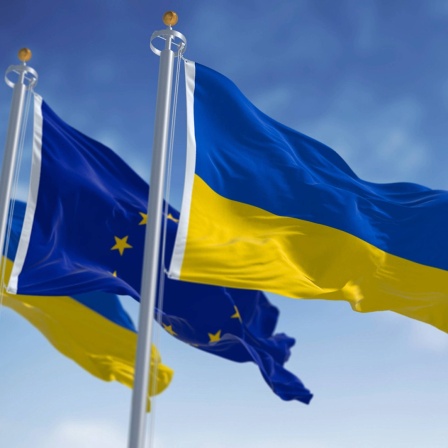 Die Flaggen der EU und der Ukraine wehen nebeneinander im Wind.
