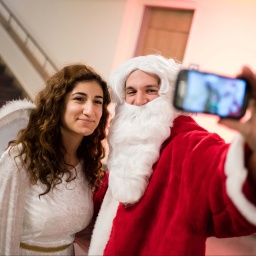 Weihnachtsmann und Engel machen ein Selfie