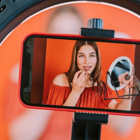 Teenage girl filming make-up tutorial at home