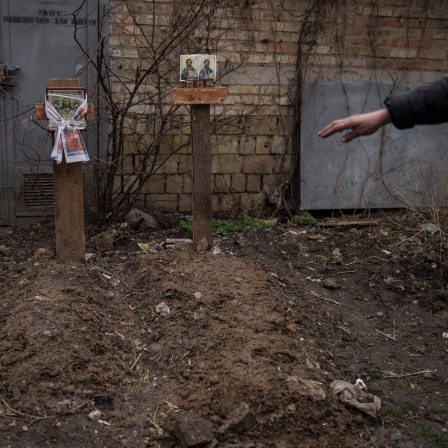Das Beitragsbild des Dok5 "Der Totengräber von Butscha - Stimmen aus einer geschundenen Stadt" zeigt ein Grab von zwei Zivilisten, die in einem Hinterhof in Butscha begraben wurden. 