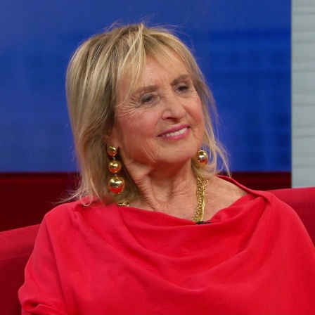 Die Schauspielerin Diana Körner auf dem roten Sofa.