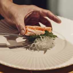 Symbolbild Haute Cuisine: Ein Koch richtet ein Fischgericht auf einem Teller an