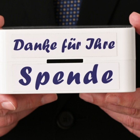 Mann hält Büchse mit Aufschrift Danke für Ihre Spende