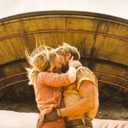 Ein Mann und eine Frau küssen sich vor einem abgestürzten Raumschiff