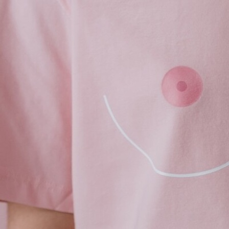 Ein rosa T-Shirt auf dem eine Brust gezeichnet ist