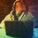 Ein Hacker sitzt vor einem Computer.