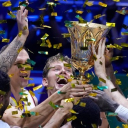 Die deutschen Spieler halten die Trophäe in die Höhe, sie sind umgeben von goldenem Konfetti.