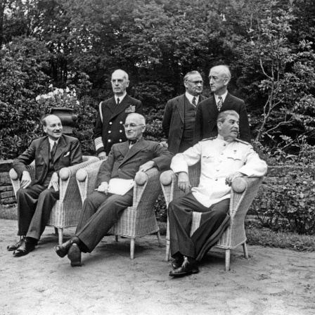 Potsdamer Konferenz - (v.l.n.r.) Clement Attlee, US-Präsident Harry S. Truman, Josef Stalin; stehend dahinter: US-Admiral William Daniel Leahy, Ernest Bevin und US-Außenminister James F. Byrnes