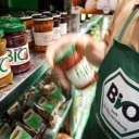 Auf einem Messestand der Grünen Woche 2007 stehen Biolebensmittel in einem Regal. Einer Person davor trägt eine grüne Schürzte mit einem Aufdruck "Bio nach EG-Öko-Verordnung"
