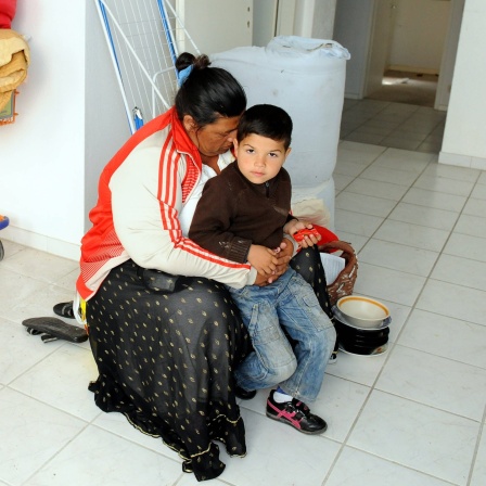 Eine Roma-Familie steht in Berlin in der neuen Wohnung der Familie.