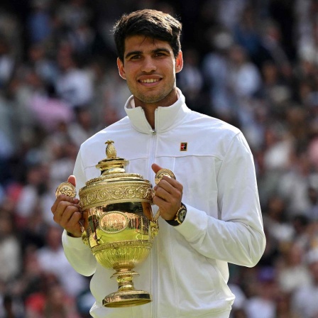 Carlos Alcaraz posiert mit Trophäe nach seinem Sieg in Wimbledon