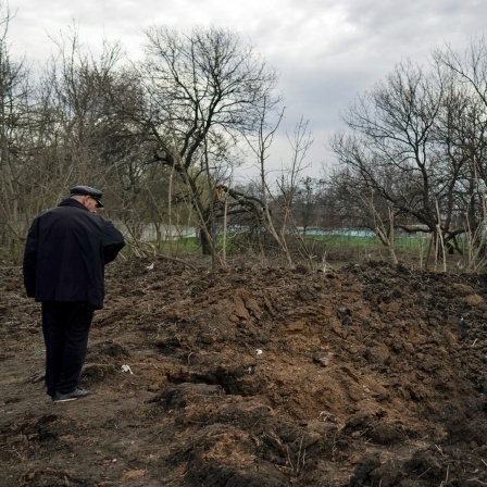 Ein Mann betrachtet in Kramatorsk den Krater einer Explosion nach einem russischen Angriff. 