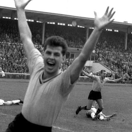 Der Dortmunder Torschütze Timo Konietzka (hinten, r) und sein Teamgefährte Lothar Emmerich (vorn) bejubelt das erste Tor beim Start der Fußball-Bundesliga am 24.08.1963 im Bremer Weserstadion.