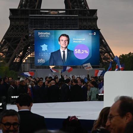 Eine Multimediatafel zeigt President Macron in Paris