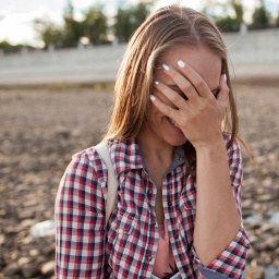 Mädchen hält sich die Hand vor die Augen