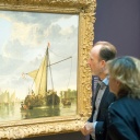 Zwei Besucher einer Ausstellung vor einem Gemälde von Aelbert Cuyp.