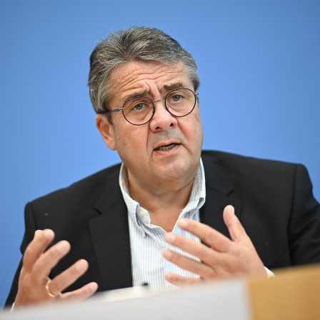 Sigmar Gabriel (SPD), Vorsitzender der Atlantik-Brücke e.V., spricht über die Situation in den USA vor der Präsidentschaftswahl. Er steht dabei vor einem blauen Hintergrund und gestikuliert beim sprechen.