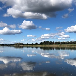 Wolken spiegeln sich in der Elbe.